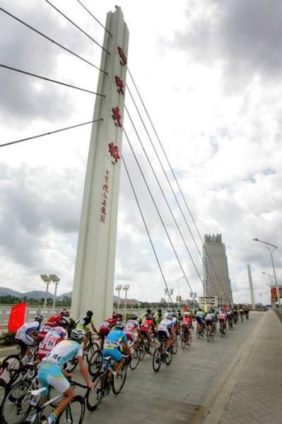 The peloton leave the bustling head over a bridge near the town of Lingshui.