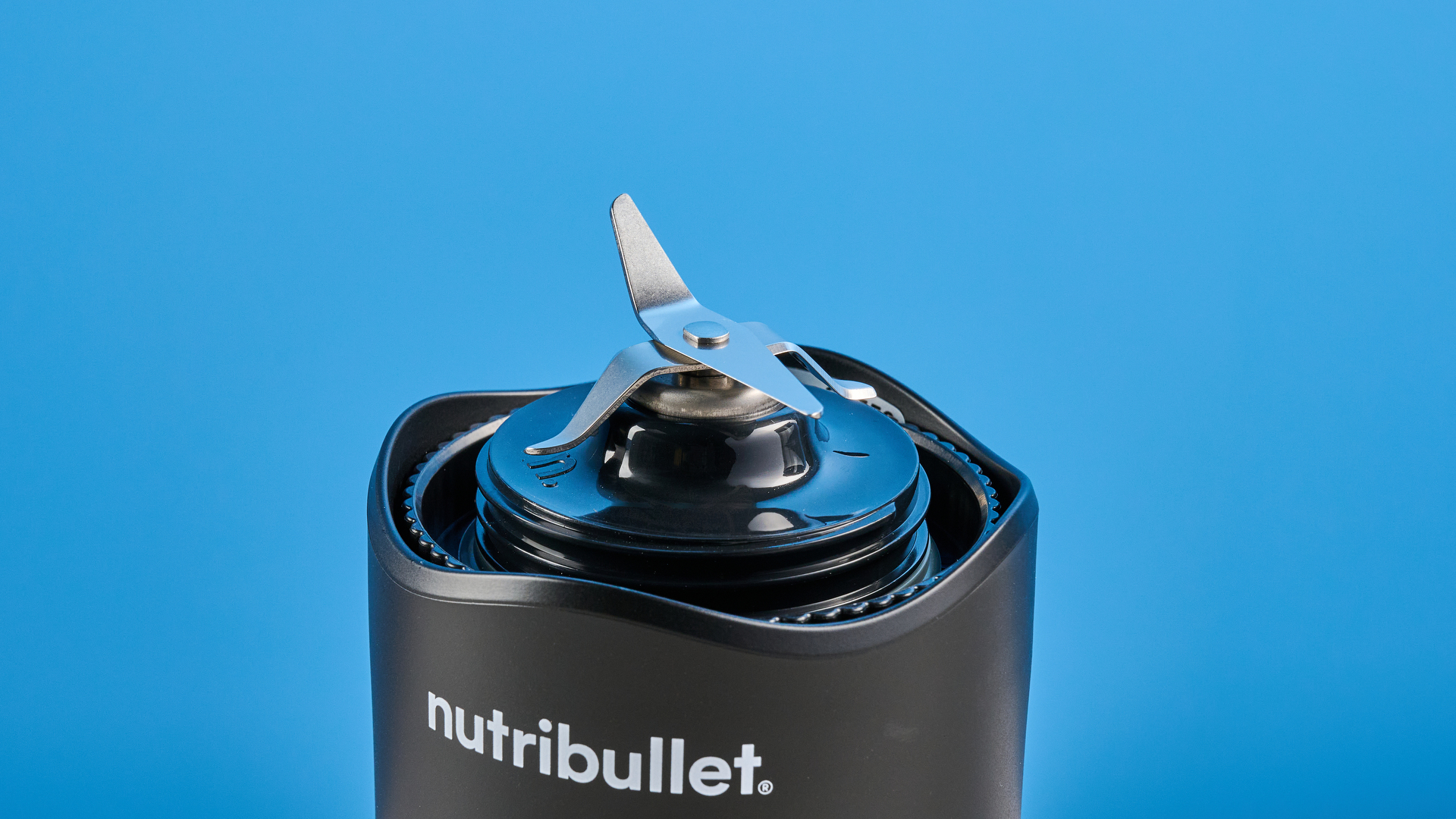Nutribullet Flex blender photographed on a blue background