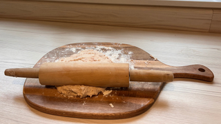 A rolling pin and wooden board with the homemade cat treats dough on it