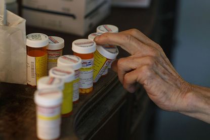 A person lines up their prescription bottles.
