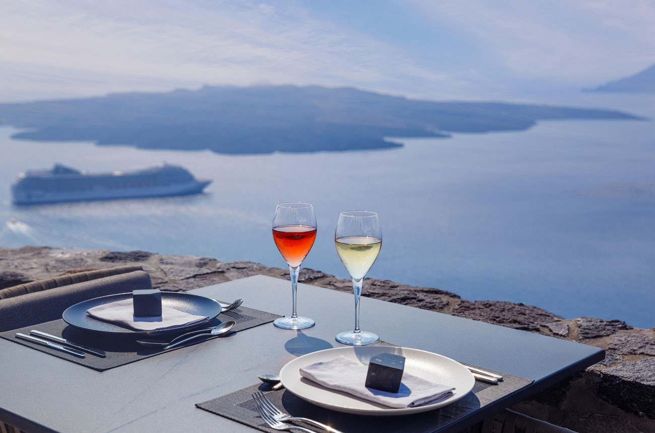 Glasses of wine on a table with the sea in the background
