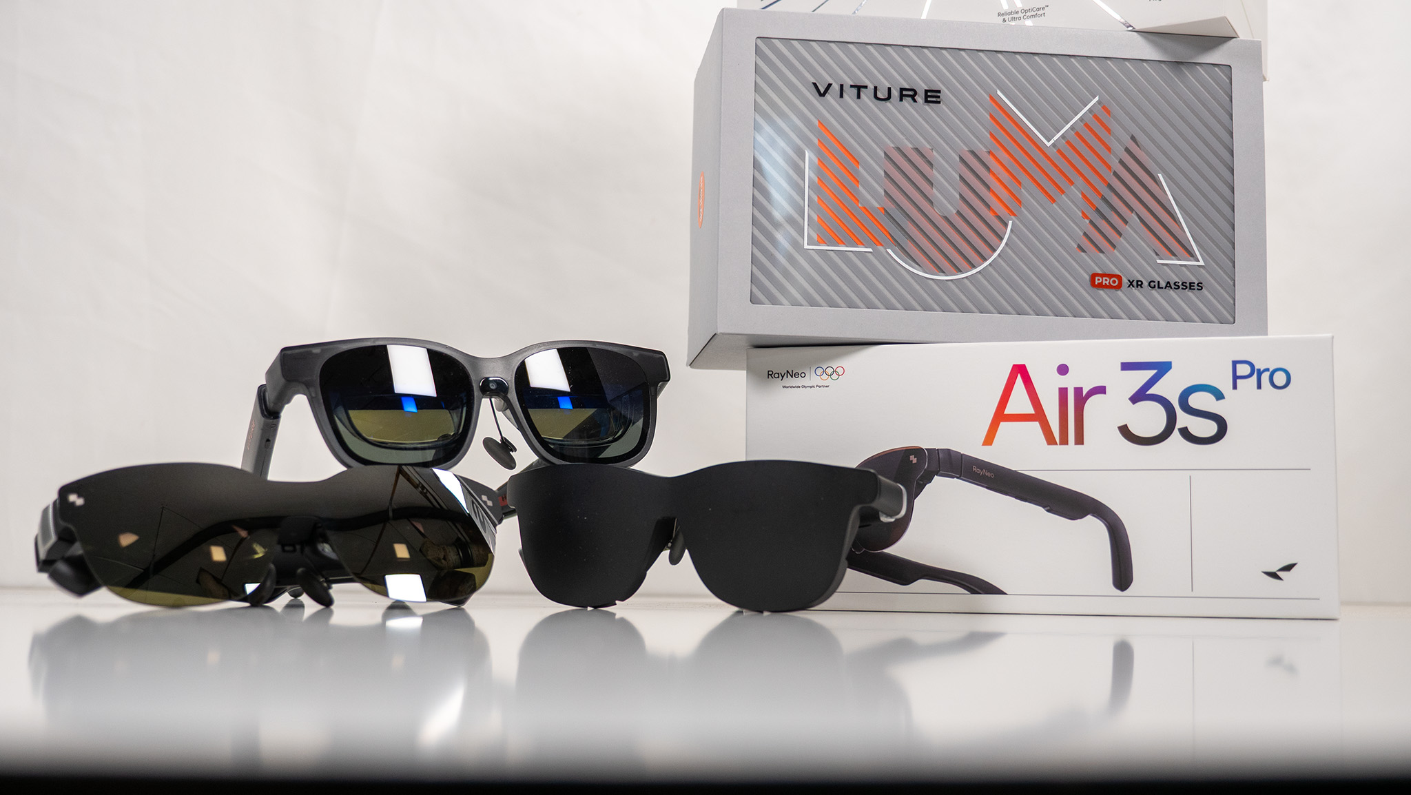 Viture Luma Pro, Viture Pro, and RayNeo Air 3s Pro smart display glasses stacked next to their boxes