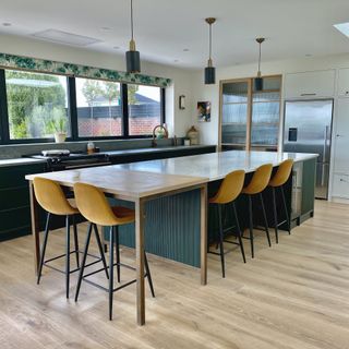 dark green and white kitchen with oak floors