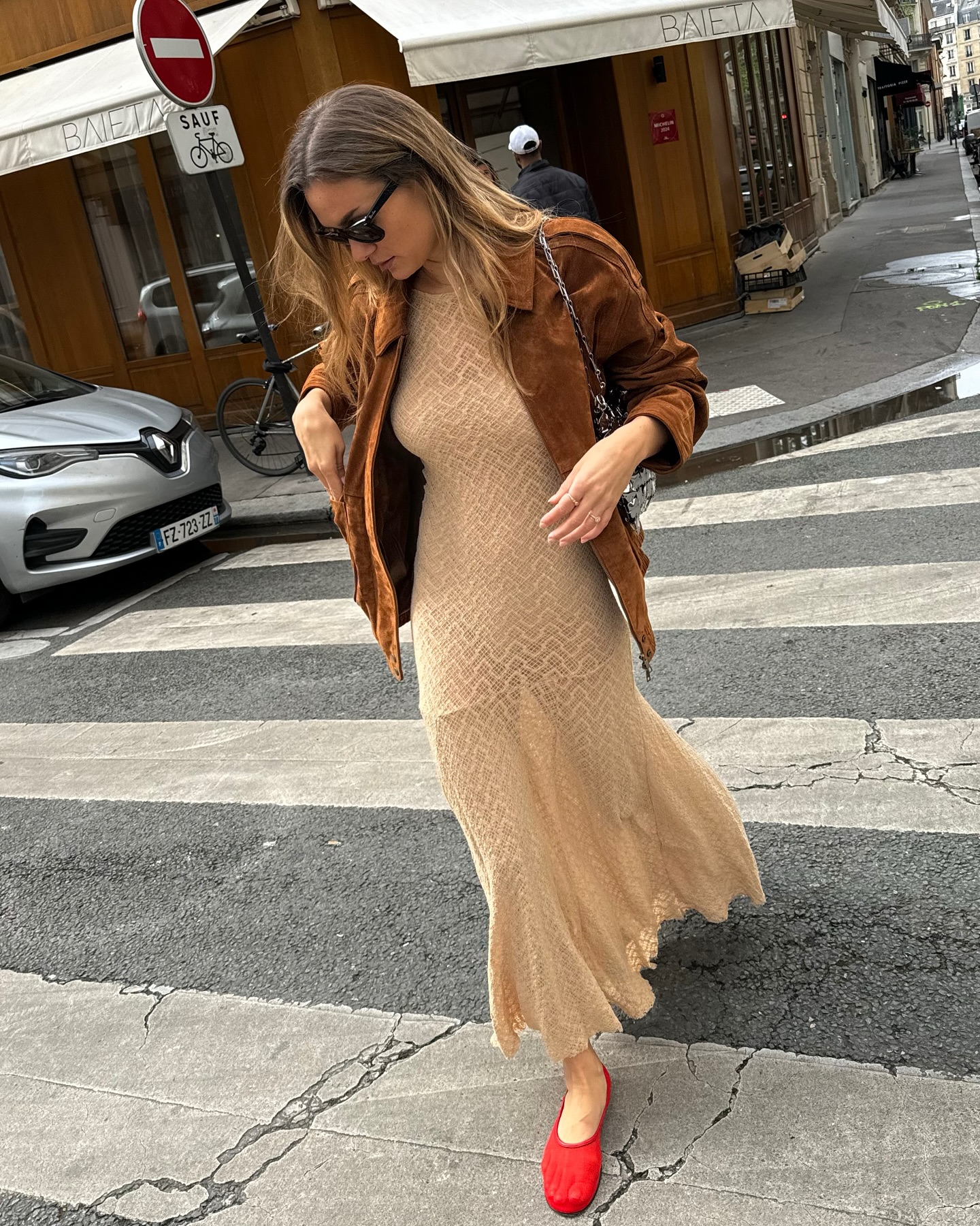 An image of @annelauremais wearing a suede jacket with a crochet dress, once of the biggest spring jacket trends to wear with dresses.