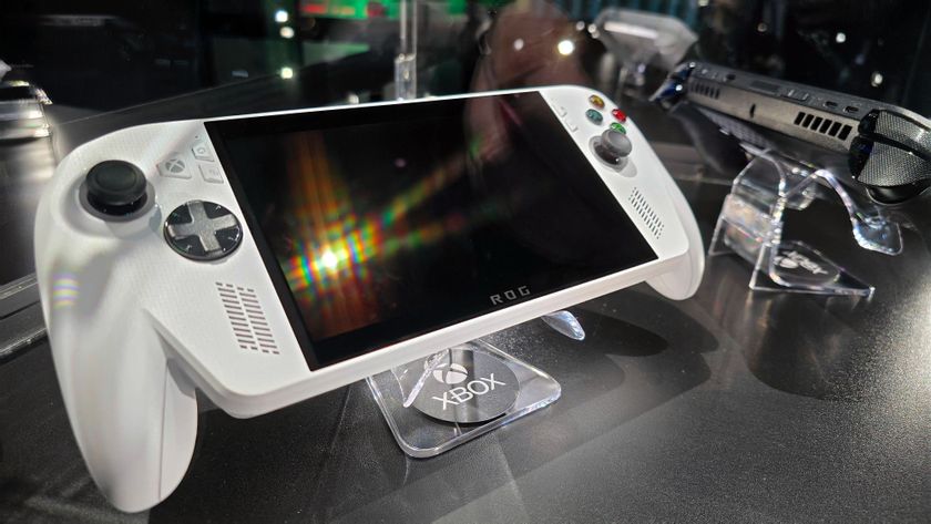 ASUS ROG Xbox Ally (white) and ROG Xbox Ally X (black) in a glass display case at Gamescom in August, 2025.