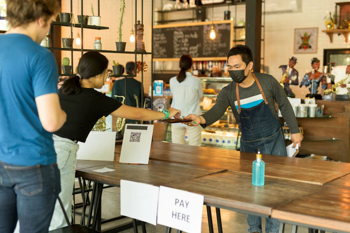 Restaurant worker wearing a mask while serving customers