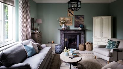 Light blur living room, comfy sofa, cushions, oval table, armchair, cupboard, paintings