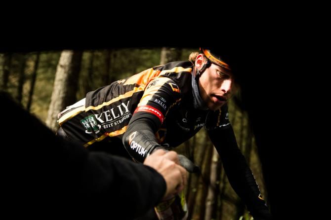 A focused Tom Soladay grabs a bottle from the team car during the Klasika Primavera de Amorebieta