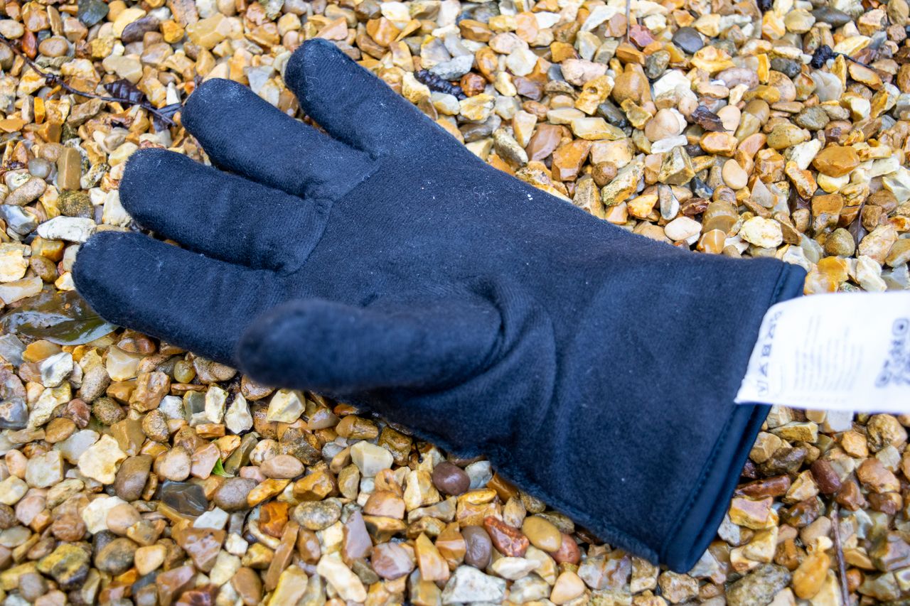 A pair of blue Madison DTE waterproof gloves on gravel