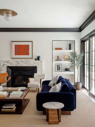 Living room with white walls, black trim and marble fireplace