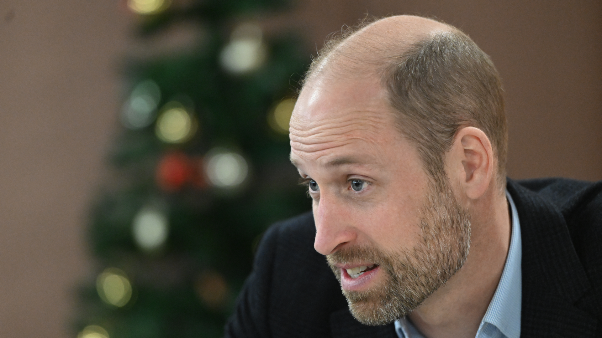 Prince William in front of a Christmas tree