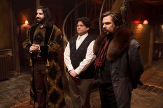 Kayvan Novak, Harvey Guillen, and Matt Berry a a group of vampires in a spooky house in a still from what we do in the shadows