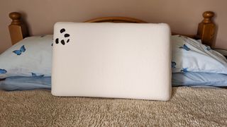 The Panda Memory Foam Bamboo Pillow on a bed