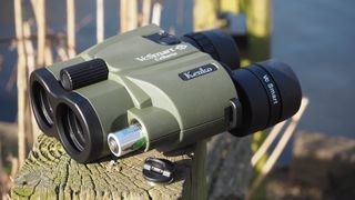 Kenko VC Smart Cellarto 10x30 WP binoculars on a wooden bench outside in front of a lake