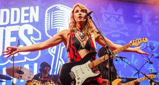 Ana Popovic stretches her arms out wide as she works the crowd during a 2024 show in Norway. She is playing her trust Fender Strat
