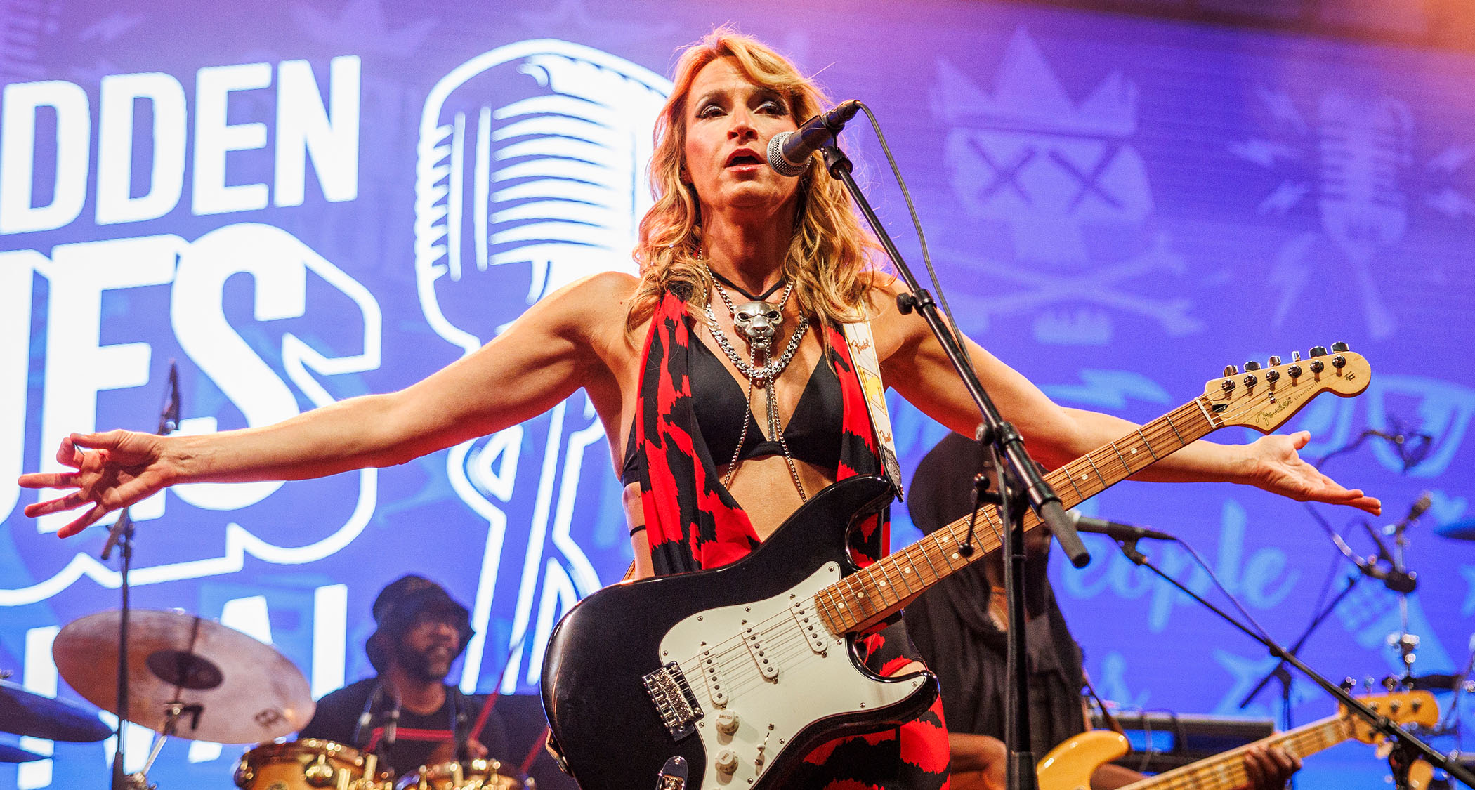 Ana Popovic stretches her arms out wide as she works the crowd during a 2024 show in Norway. She is playing her trust Fender Strat