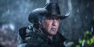 Rambo wearing a cowboy hat in a torrential storm