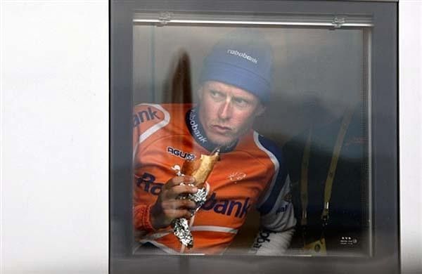 Michael Rasmussen (Rabobank) bites into a sandwich before the doping control. The dude in the background is hopefully making sure Rasmussen doesn't trick anybody.