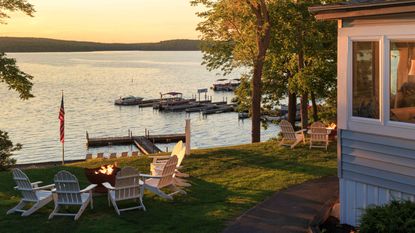 A view of a possible vacation home on the water with a bonfire. 