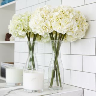 bathroom with white tiles and flower with vase