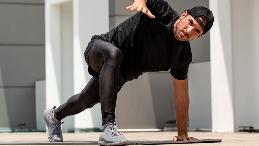 Young sportsman warming up with spider lunge exercise outdoors on building rooftop floor