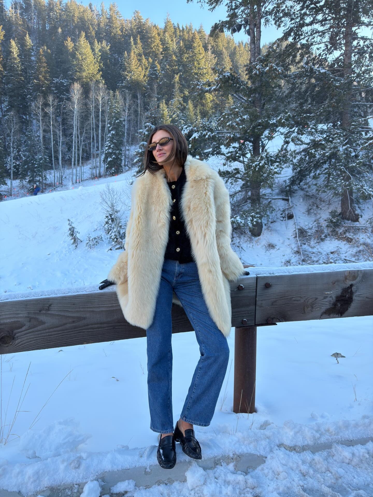 Coco Schiffer wears an apres-ski faux fur coat outfit in the mountains.