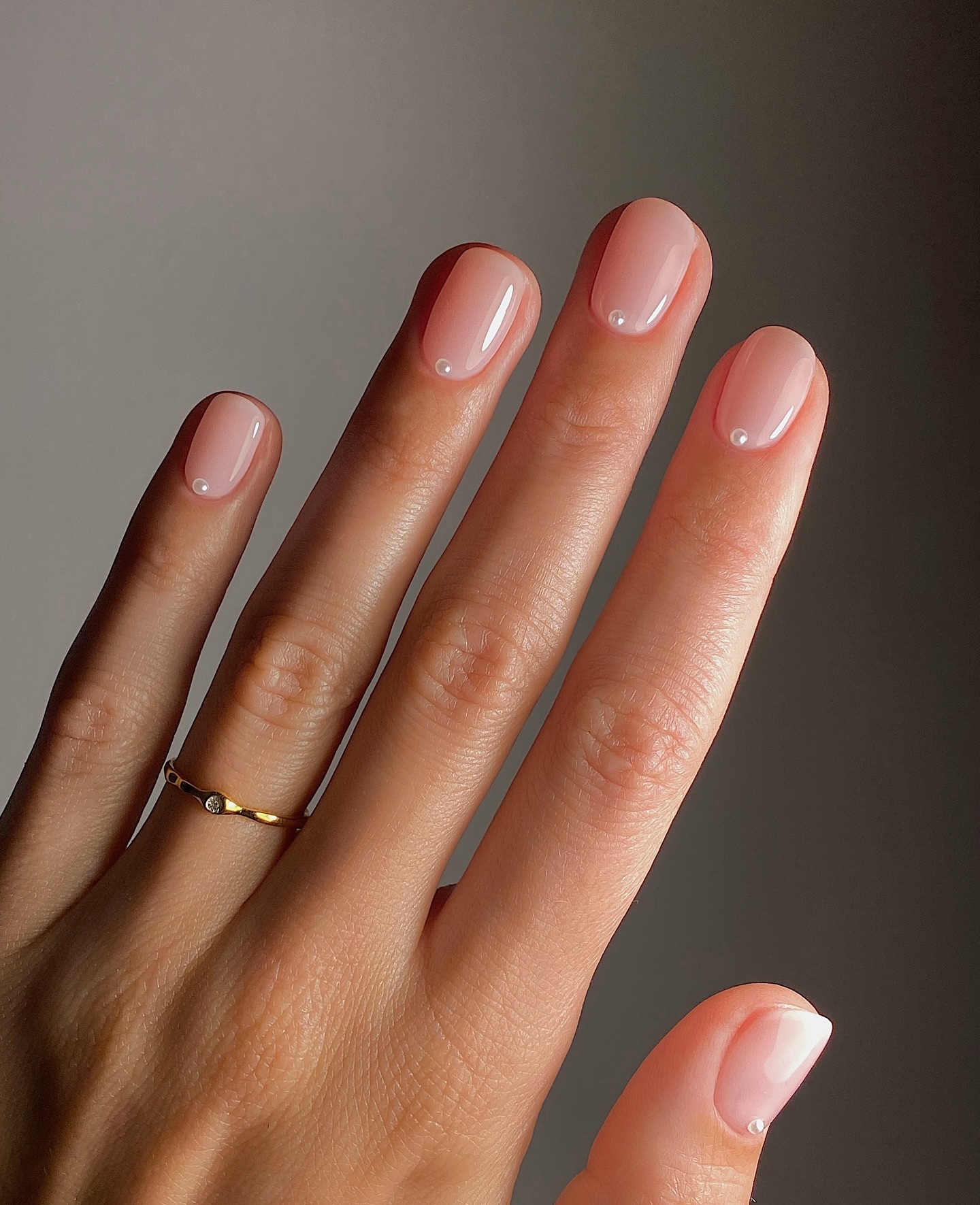 A manicure with soft pearls placed at the top of the nails by Mate Janova