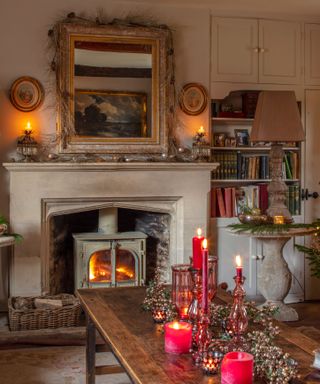 fireplace in a farmhouse living room decorated for christmas with candlelight