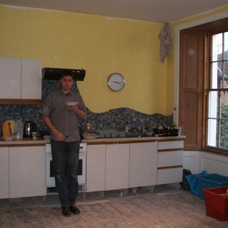 kitchen with plain white units and yellow walls