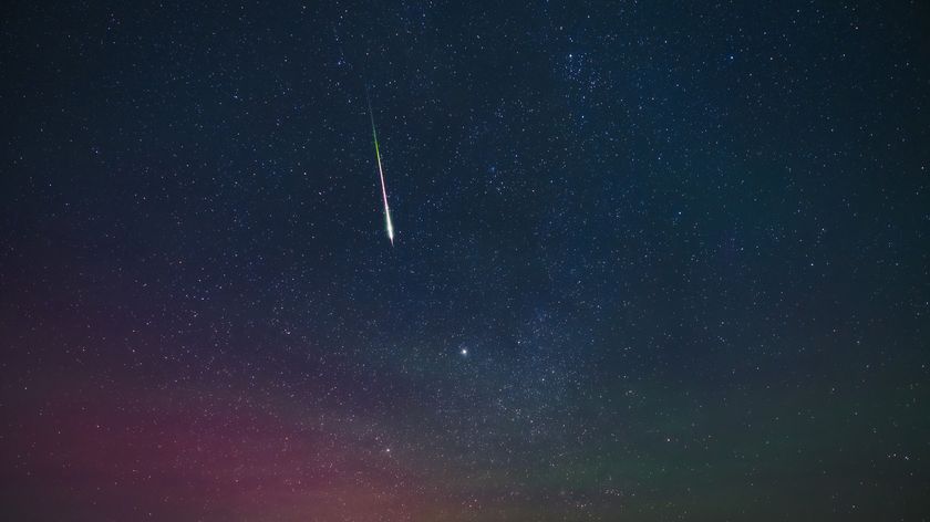 bright shooting star with a long train streaking through the star studded sky.
