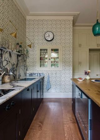 apartment kitchen with dark cabinets and marble work surfaces and kitchen wallpaper