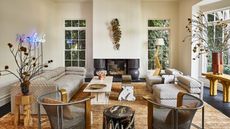 large cream living room with symmetrical layout but a mox of modern and vintage furniture