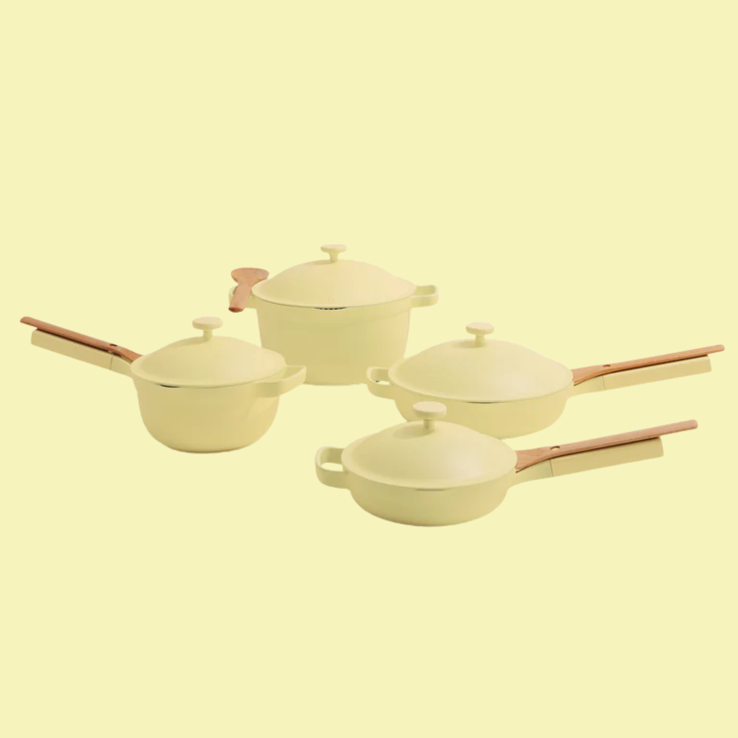 A set of four pots and pans in butter yellow