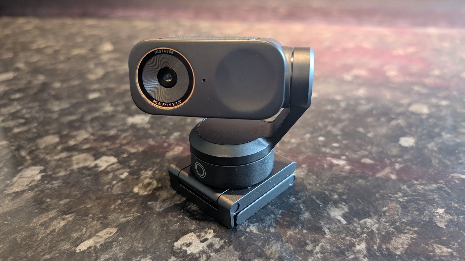 The Insta360 Link 2 Pro webcam, pictured on a marble worktop.