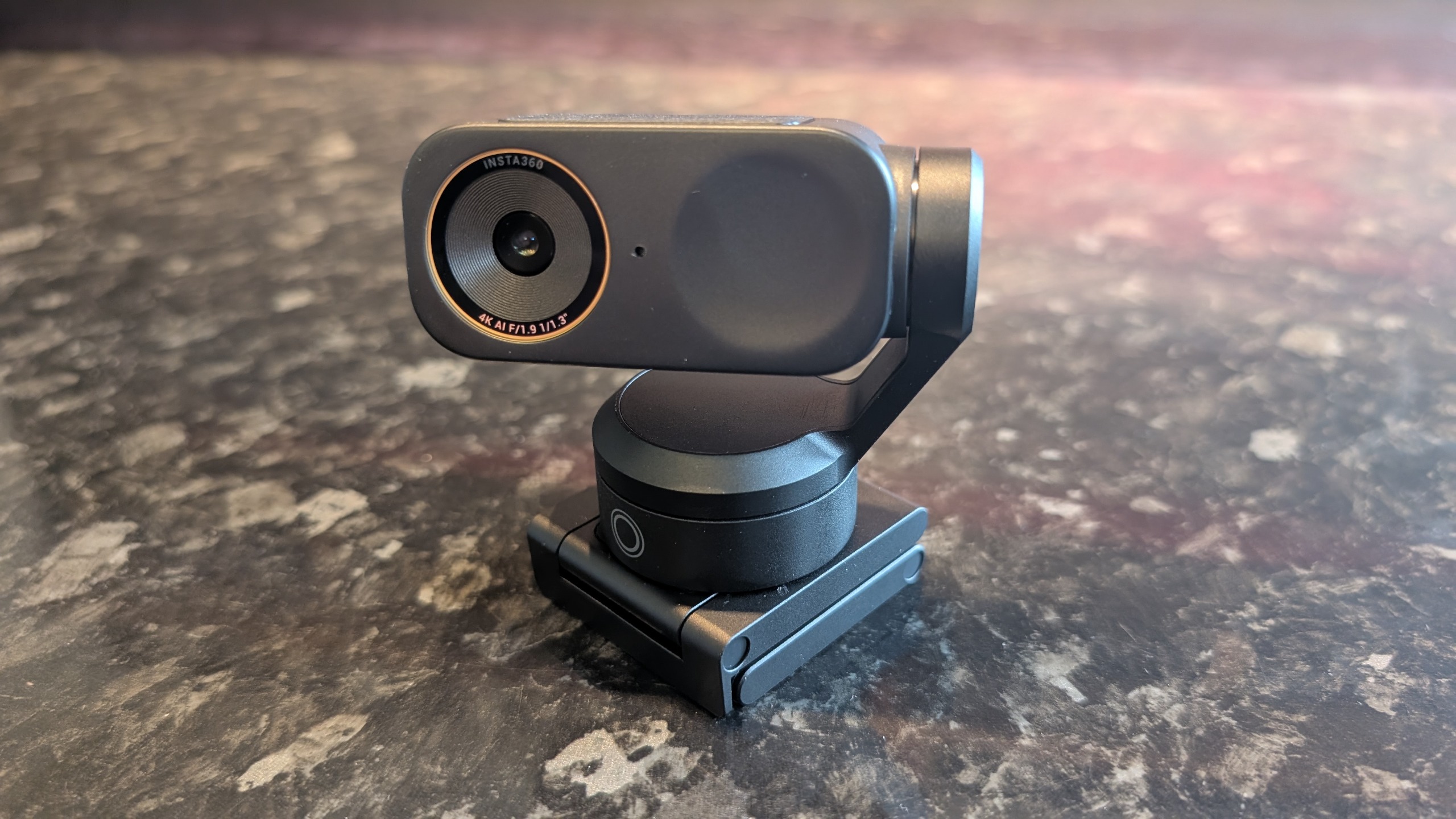The Insta360 Link 2 Pro webcam, pictured on a marble worktop.