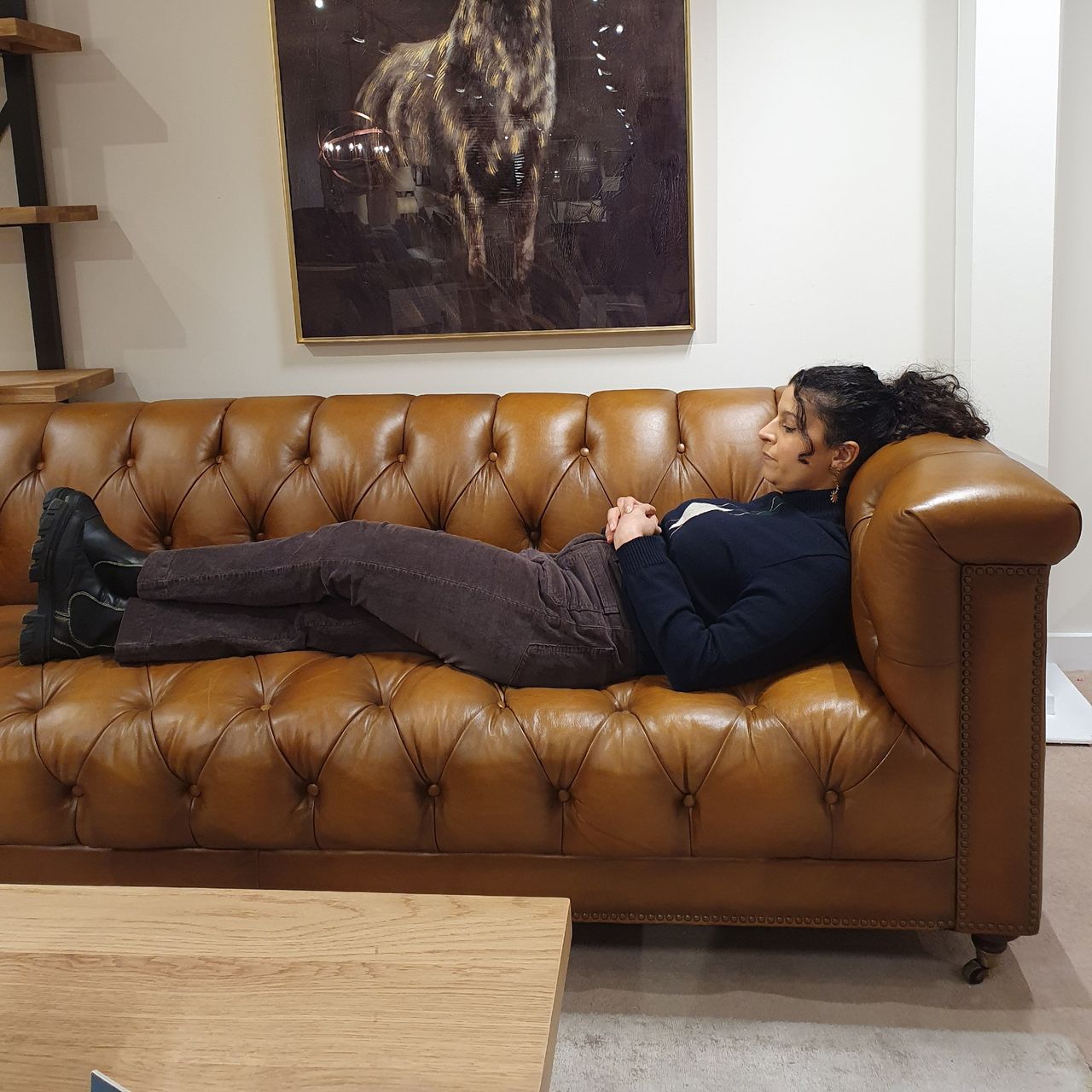 Sara lying down on the Furniture Village Wallace At The Helm Connaught sofa