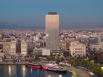 Piraeus Tower seen in its urban context, facade gleaming in the dusk light