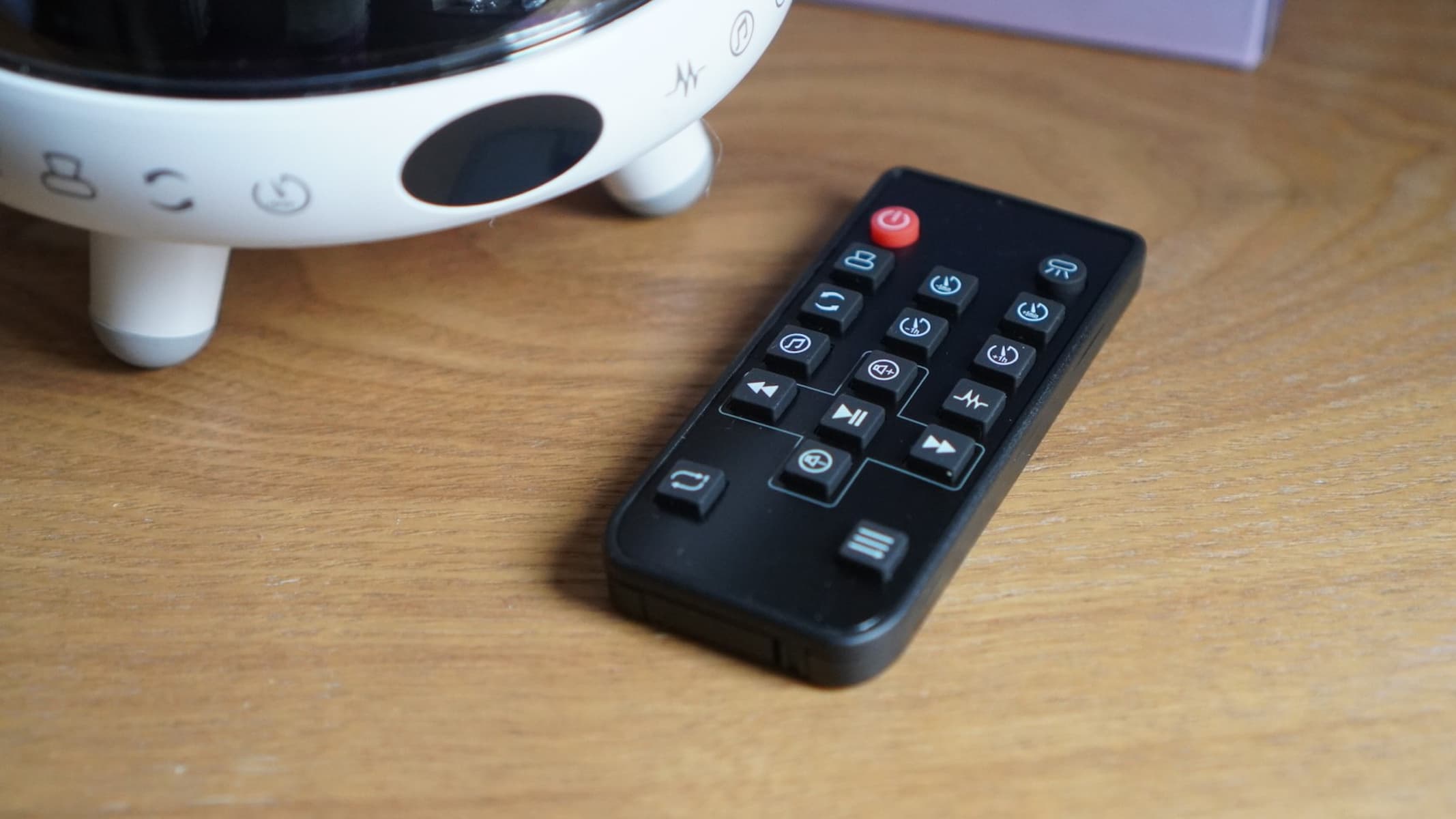 جهاز التحكم عن بعد لجهاز عرض النجوم Yachance Night Light، على الطاولة. 