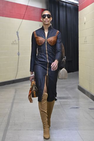 A'ja Wilson #22 of the Las Vegas Aces does a tunnel walk at the 2024 WNBA playoffs wearing a denim dress with a built-in bra