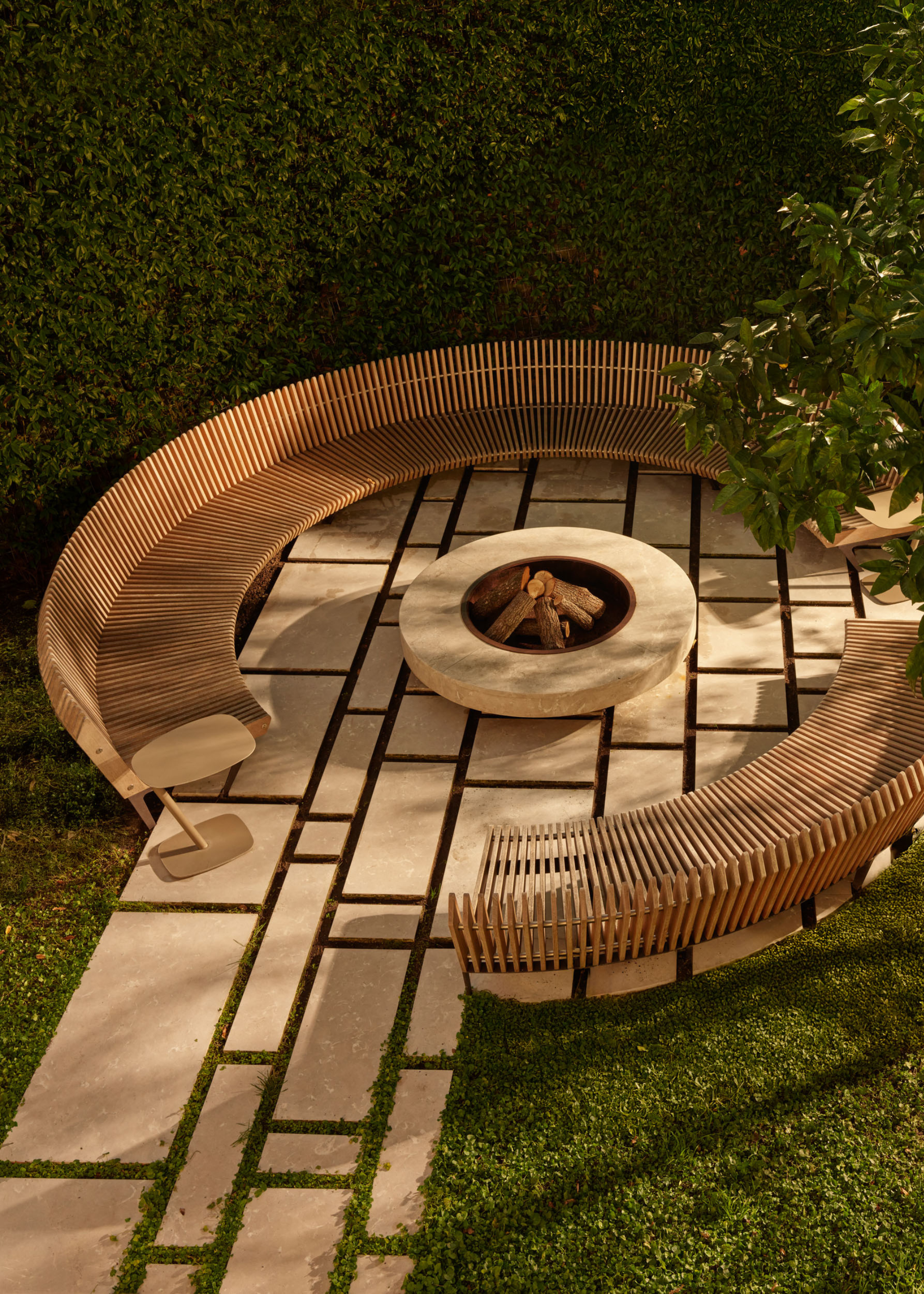 An overhead shot of a wooden bench and a circular fire pit