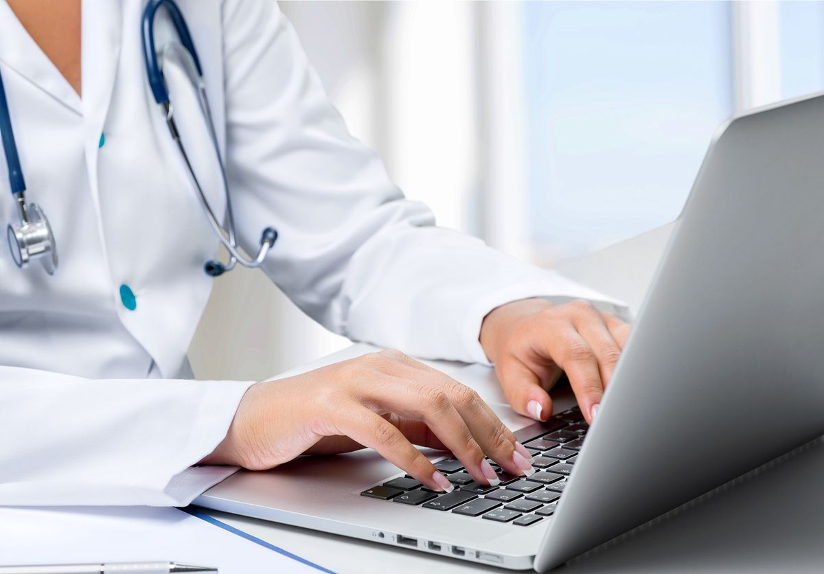 Doctor typing on a laptop