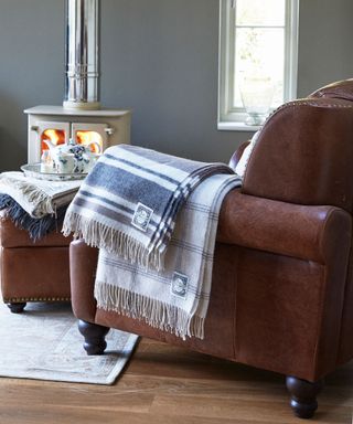 leather armchair and footstool by wood stove