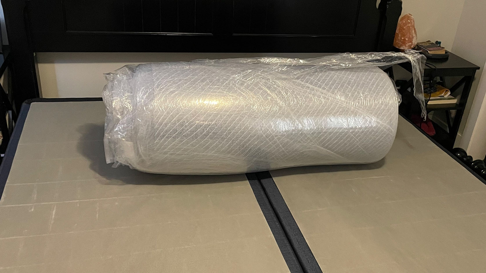 Leesa Studio mattress wrapped in plastic, vacuum-packed, on bed frame