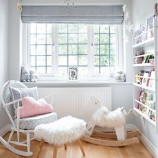 Girls nursery with grey blind and rocking chair