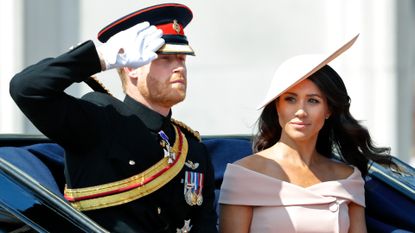 Prince Harry, Duke of Sussex and Meghan, Duchess of Sussex travel down The Mall