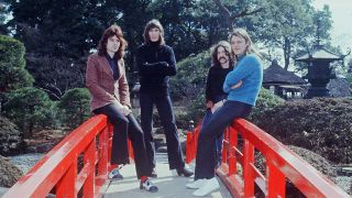 Pink Floyd standing on a bridge in a Japanese garden