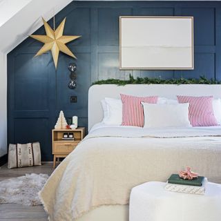 master bedroom with blue wall, king sized bed with pink bedding, and Christmas star