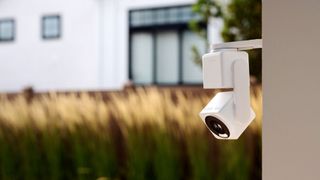 Wyze Cam Pan v4 attached to the exterior of a house with a yard in the background