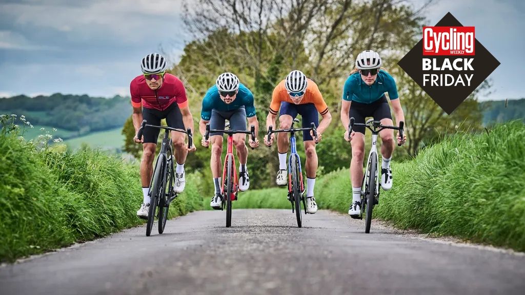 4 riders are pictured head on riding up a rode on 4 bikes