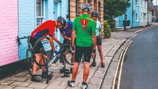 Cyclist stand around a bike upside down